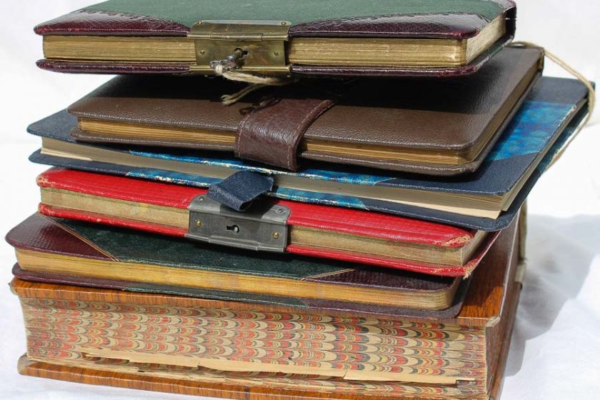 6 ältere Tagebücher liegen übereinander, zum Teil mit geöffneten Schlössern