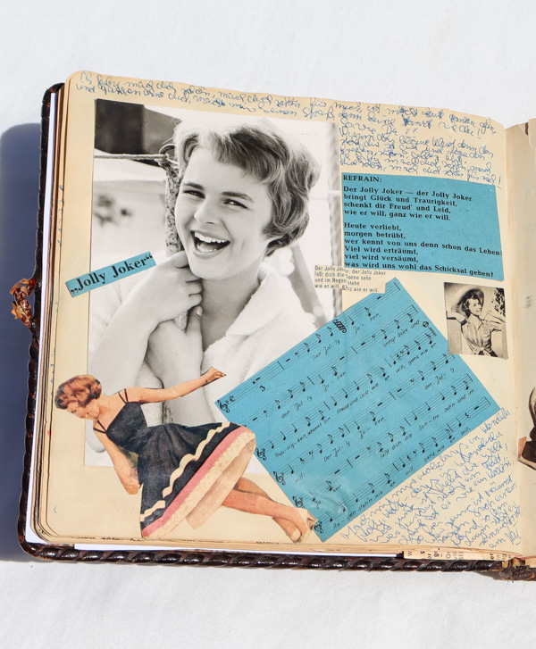 eine Tagebuchseite mit eingeklebten Fotos und Schlagertexten und Melodien.